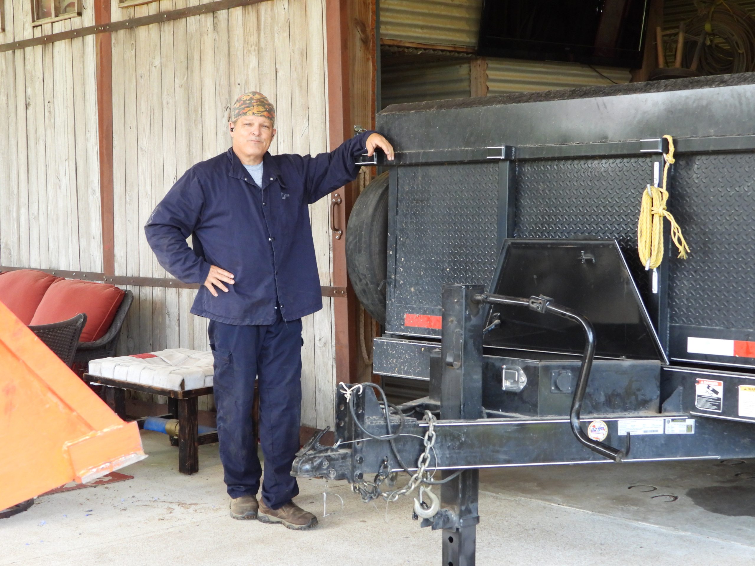 Michael standing beside a trailer in the barn