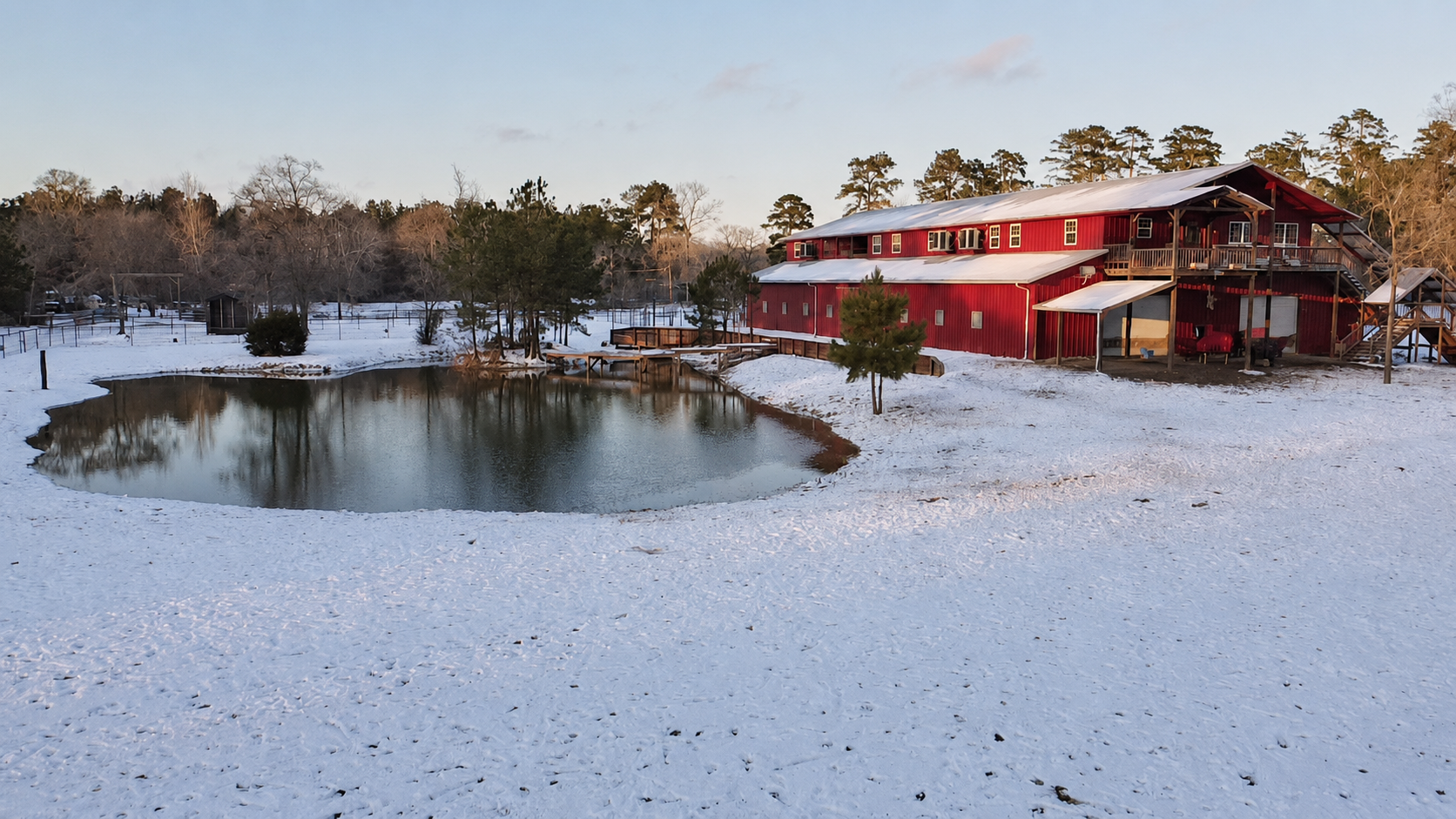 The red barn beside a pond in the snow
