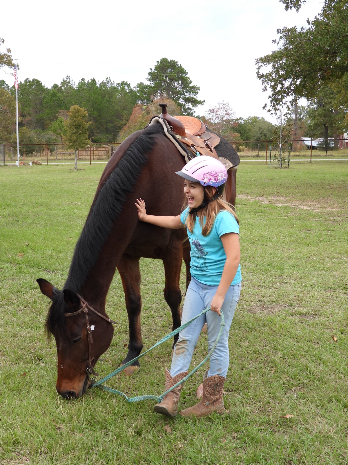 Young rider smiling while petting a horse
