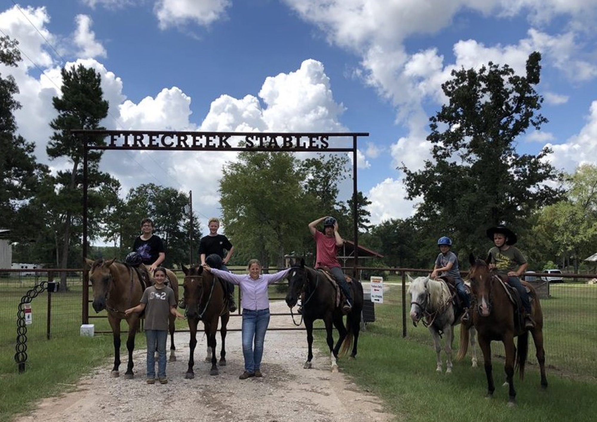 Group of young riders under the Firecreek Stables sign